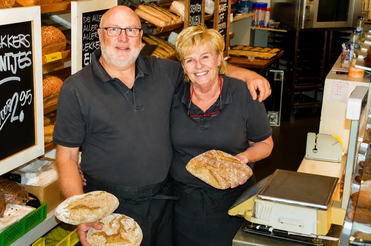 Willem en zijn collega in de winkel, allebei met een vers desembrood in de hand.